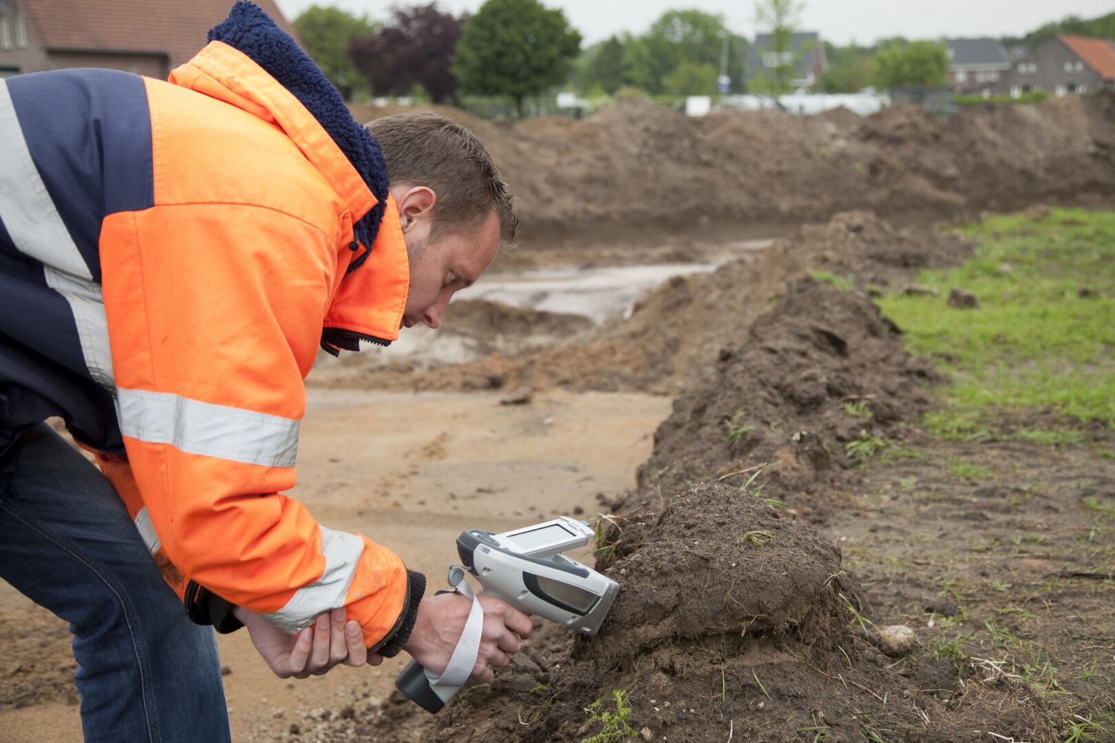 Construction worker scanning soil with handheld device