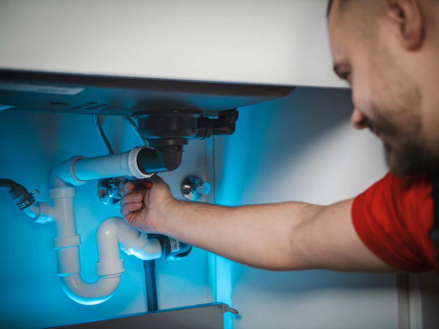 Man repairing under-sink plumbing